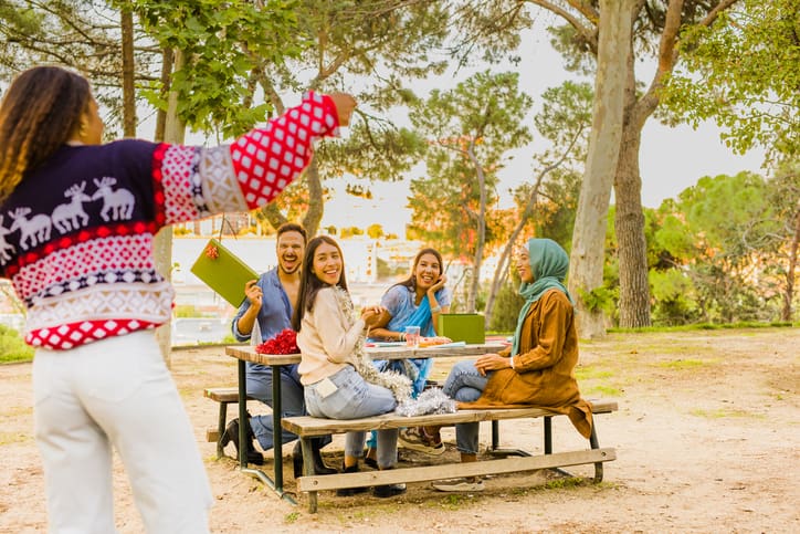 A group of friends gathering with ugly sweaters and presents. 