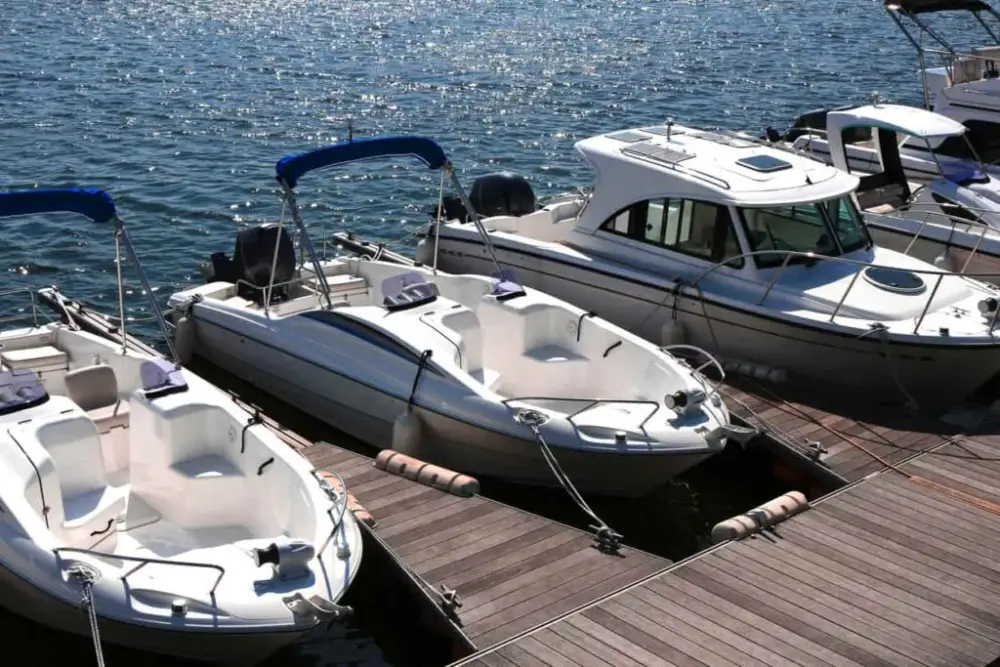 Three boats parked on the water at a marina.