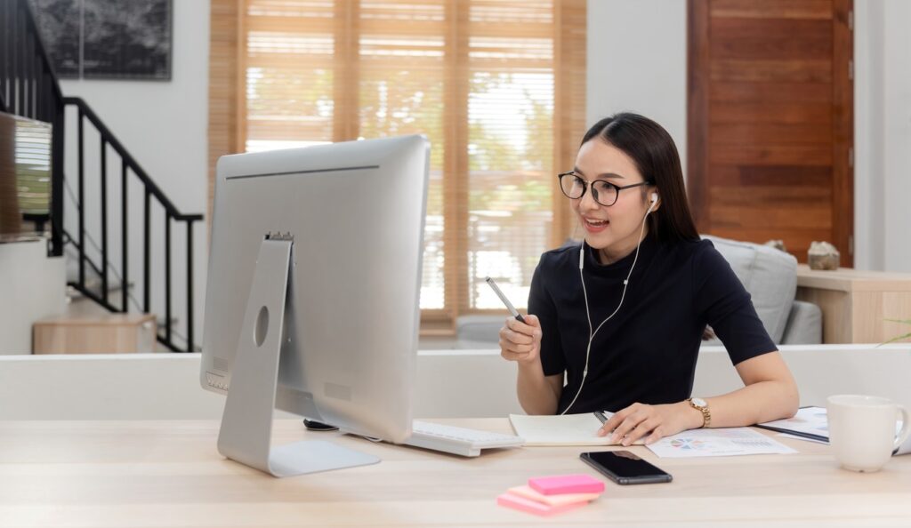 Woman working from home with a clean desk and lots of space.