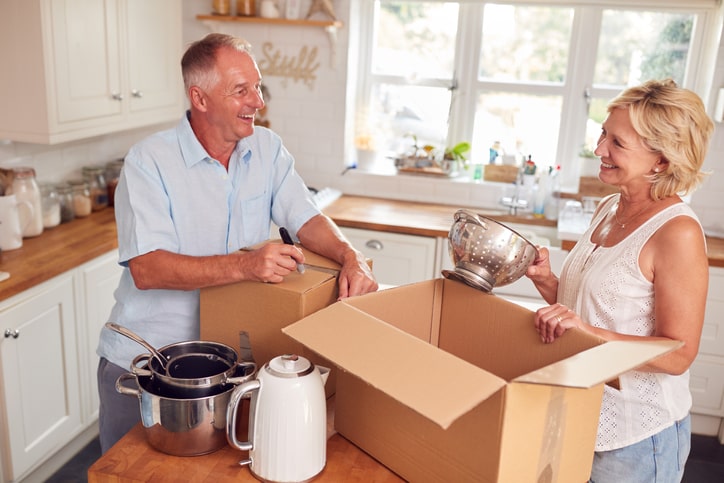 Couple putting items in boxes as they downsize and move into a new home.