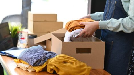 Seasonal clothing being packed into a box for storage.