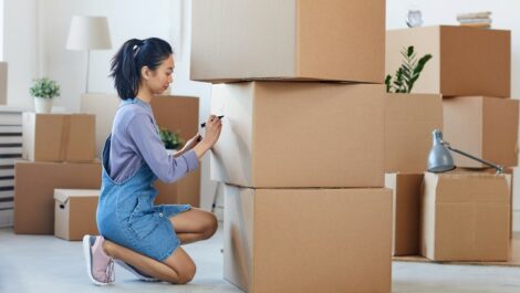 Woman labeling boxes to prepare for a move.