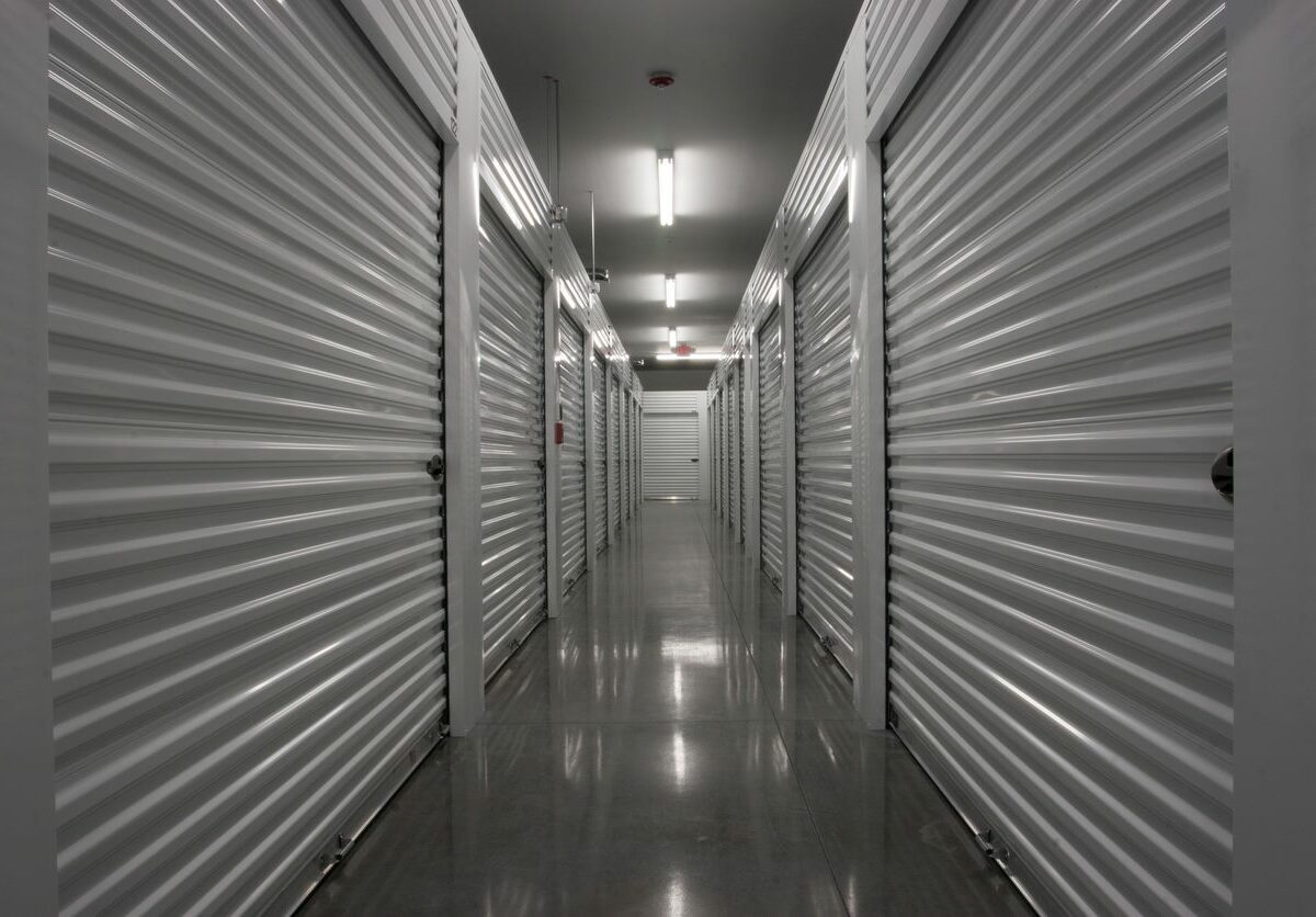 A hallway of storage units with white doors.